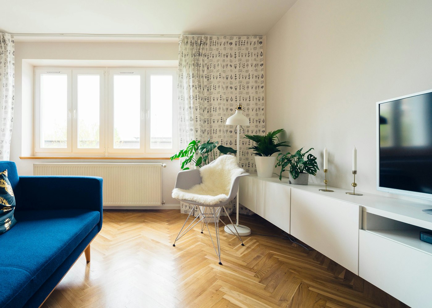 Living room with a blue sofa and herringbone floors