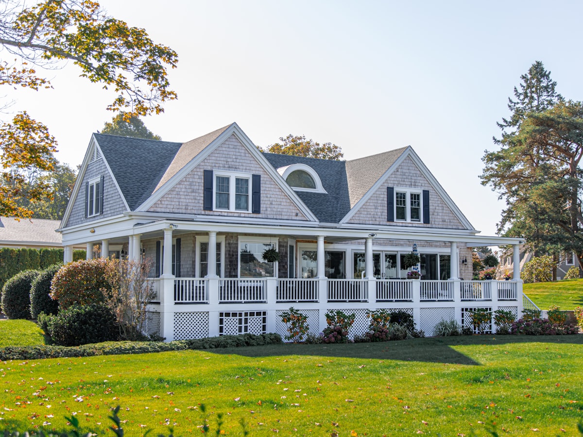 White clapboard farmhouse with a wraparound porch
